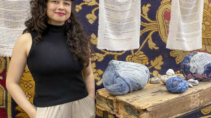 La artista colombiana Vanessa Nieto posa junto a una de sus obras expuestas en la Real Fábrica de Tapices, en el marco de la exposición 'Reencuentros para tejer la vida y los afectos'. EFE/Patricia Cotelo Bertaiola
