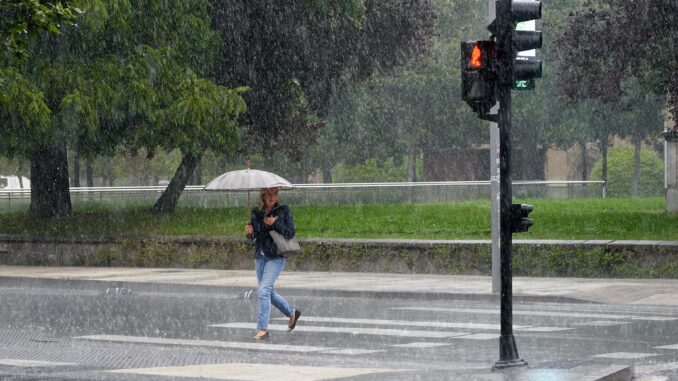 Una mujer se protege de la lluvia con un paraguas, en una fotografía de archivo. EFE / L. Rico
