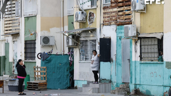 Los vecinos de las Tres Mil Viviendas observan la redada de la Policía Nacional que ha vuelto a desplegarse este viernes en esta barriada de Sevilla, en la segunda fase de la operación 'Vulcano', centrada en la lucha contra el narcotráfico y que se produce después del tiroteo con armas de combate que alarmó a los vecinos el pasado sábado. EFE/ José Manuel Vidal
