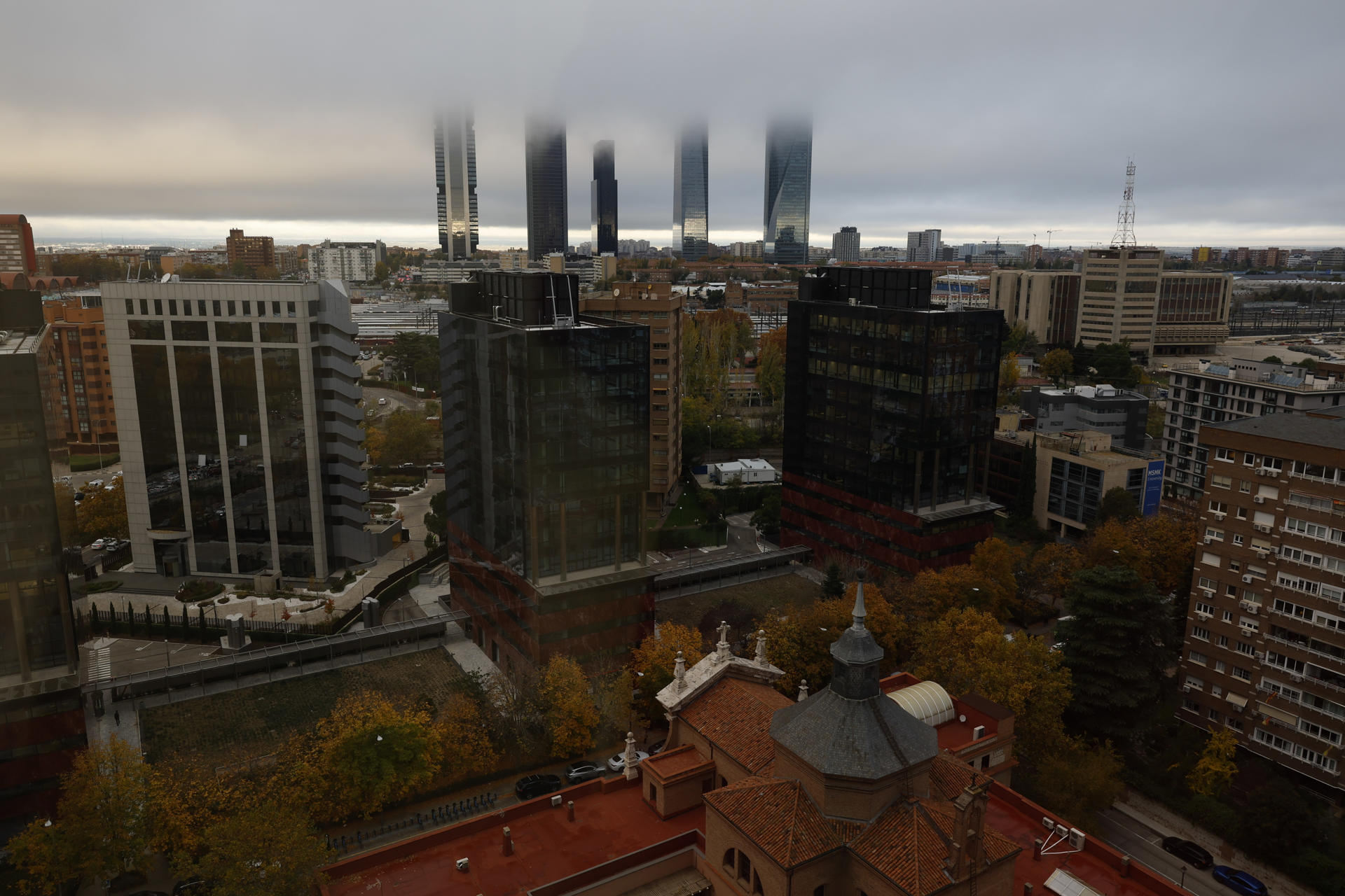 Vista la niebla en el complejo de las cinco torres de Madrid este jueves cuando según la Aemet la borrasca ‘Caetano’ será más intensa sobre el norte peninsular, y dejará cielos cubiertos, con precipitaciones persistente en norte y oeste de Galicia y vientos con rachas muy fuertes en los litorales de Galicia, cantábrico y mediterráneo. EFE/ Mariscal
