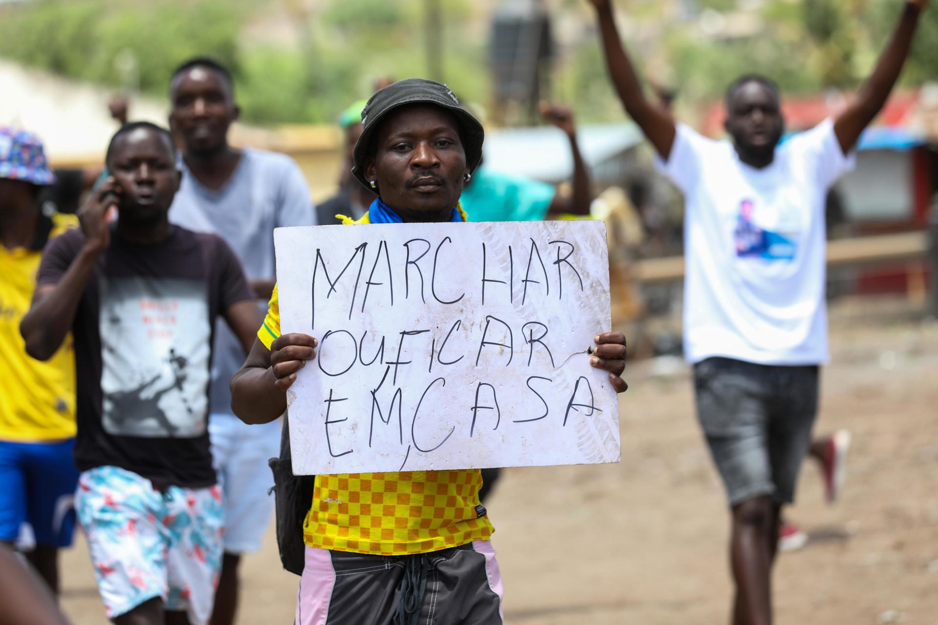 Un manifestante sostiene un cartel que dice 'marcha o quédate en casa' mientras los simpatizantes del candidato presidencial Venancio Mondlane protestan exigiendo la 'restauración de la verdad electoral', cortando el tráfico en Ressano Garcia, la principal frontera entre Mozambique y Sudáfrica, Mozambique, 14 de noviembre de 2024. La Comisión Nacional Electoral (CNE) el 24 de octubre publicó los resultados de la tabulación general de las elecciones del 09 de octubre - presidenciales, legislativas y de asambleas provinciales - anunciando la victoria del partido en el poder, el Frente de Liberación de Mozambique (Frelimo), con 11 escaños más en el parlamento. El candidato presidencial de Frelimo, Daniel Chapo, quien fue elegido con el 70.67 por ciento de los votos, sucederá al presidente actual, Filipe Nyusi. Estos resultados fueron impugnados por la oposición, que afirmó que había irregularidades. (Elections, Protests, South Africa) EFE/EPA/LUISA NHANTUMBO
