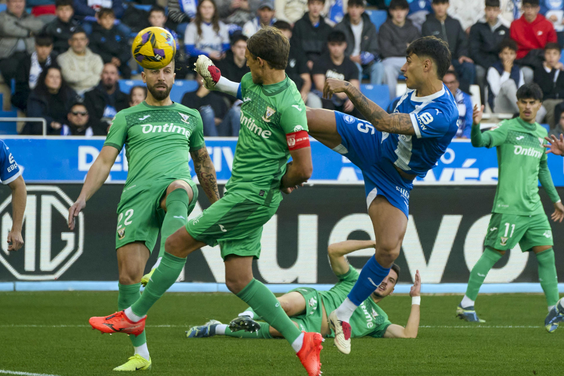 El delantero del Alavés Carlos Martín (d) dispara a portería ante dos rivales del Leganés, durante el partido de LaLiga disputado este sábado en el estadio de Mendizorroza. EFE/ L. Rico
