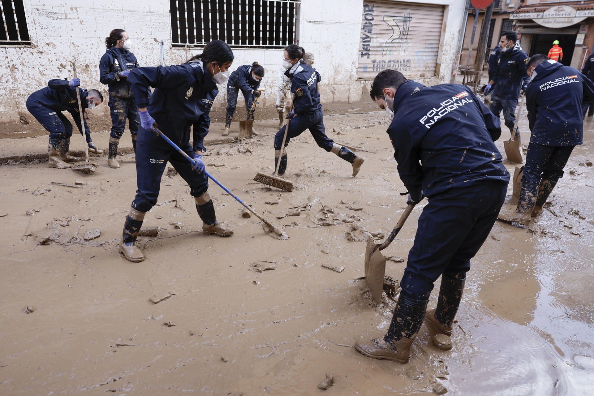 Alumnos de la Escuela de Policía Nacional de Ávila ayuda en la limpieza de Masanasa (Valencia) este jueves. Los pueblos de Valencia asolados por la dana afrontan el noveno día después de la catástrofe sumidos en un goteo incesante de llegada tanto de ayuda humanitaria como profesional y de maquinaria pesada, para intentar recuperar infraestructuras, colegios, zonas industriales y vías de comunicación mientras continúa la búsqueda de desaparecidos. EFE/Kai Försterling
