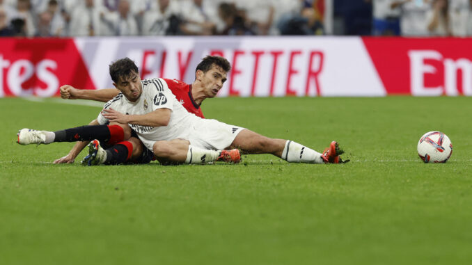 El centrocampista del Real Madrid Raúl Asencio despeja desde el suelo durante el partido de la jornada 13 de LaLiga entre Real Madrid y Osasuna, en el estadio Santiago Bernabéu en Madrid.-EFE/ Javier Lizón
