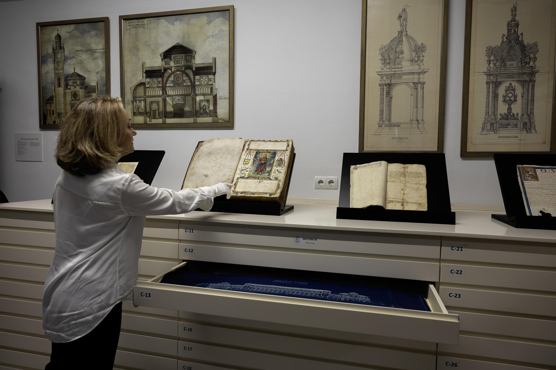 Beatriz Lafuente, coordinadora de los fondos documentales muestra uno de los ejemplares que atesora el Archivo Histórico Diocesano de Málaga desde la partida bautismal de Pablo Ruiz Picasso hasta documentos firmados por los Reyes Católicos, joyas que reúne libros de bautismo, matrimonio y defunción de Málaga desde principios del siglo XVI. EFE/Jorge Zapata
