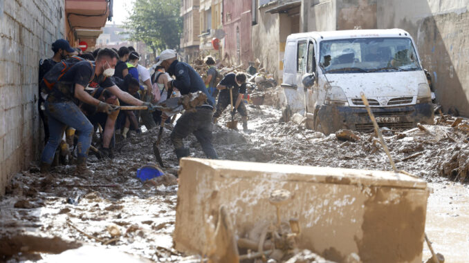 Un grupo de voluntarios saca lodo de una de las calles de Massanassa (Valencia). EFE/Miguel Ángel Polo
