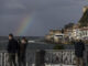 Turistas observan el arco iris en la playa de la Concha de San Sebastián. EFE/Juan Herrero