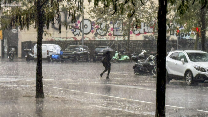 Una persona camina bajo la lluvia en Barcelona bajo la lluvia. EFE/Alberto Estévez
