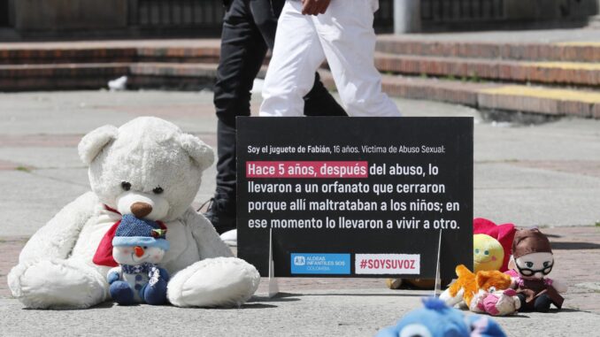 Fotografía de archivo de varios juguetes junto a un cartel de protesta que resume una historia de abuso a un niño, durante un plantón en la Plaza del céntrico barrio 20 de Julio, en Bogotá (Colombia). EFE/ Carlos Ortega
