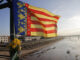 Una bandera de la Comunidad Valenciana junto a un ramillete de flores cuelga de la pasarela que va de Valencia hacia La Torre, este jueves. EFE/Ana Escobar