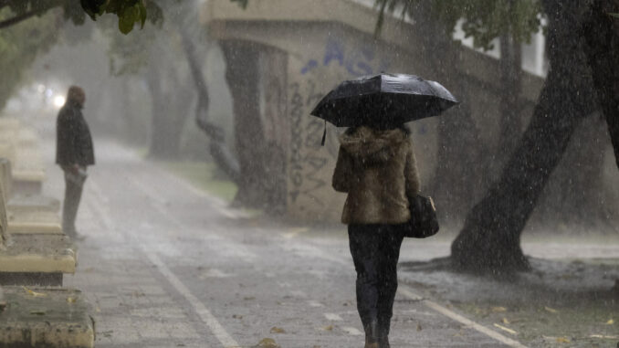 Fotografía de archivo de una mujer que se resguarda de la lluvia bajo un paraguas el pasado 29 de octubre en Málaga. EFE/Jorge Zapata.
