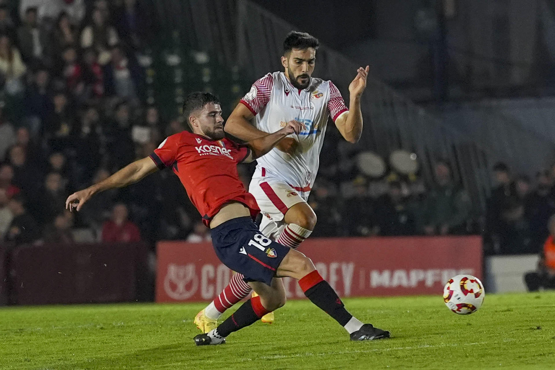 El jugador del Chiclana CF Mawi (d) disputa un balón ante el centrocampista del Osasuna Iker Muñoz este martes, durante el partido de primera ronda de Copa del Rey, entre el Chiclana CF y el Club Atlético Osasuna, en el Campo Municipal de Chiclana (Cádiz). EFE/ Román Ríos
