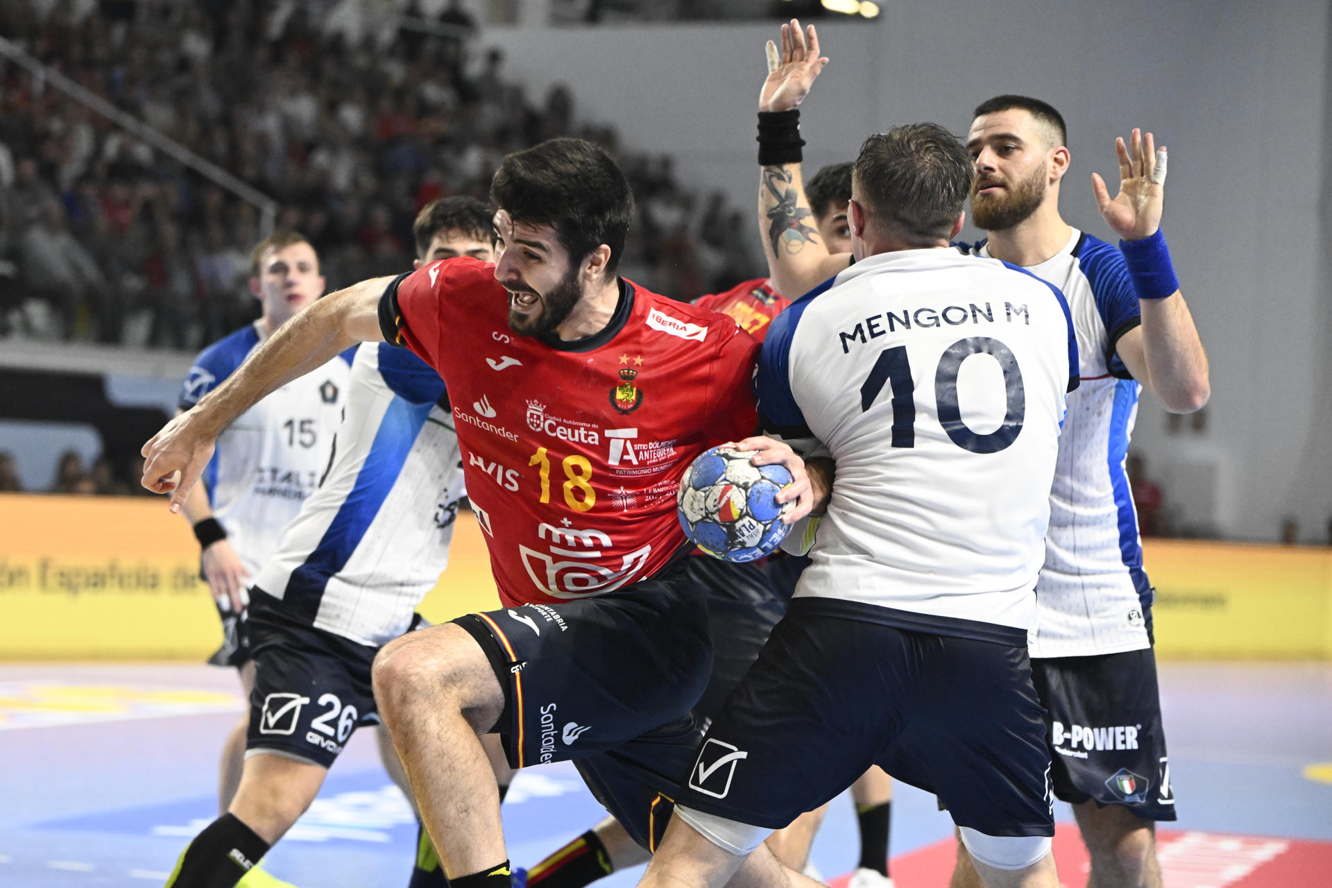 El lateral derecho de la selección española de balonmano Imanol Garciandia (i) intenta lanzar ante Marco Mengon, de la selección italiana, durante el partido de clasificación para el Europeo de 2026 que se disputa este miércoles en el Pabellón Puerto de Sagunto, en Valencia. EFE/Andreu Esteban
