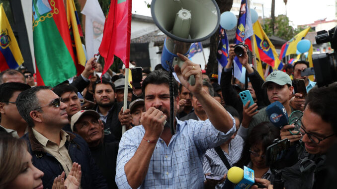 Fotografía de archivo del pasado 29 de octubre del empresario ecuatoriano especialista en seguridad Jan Topic (c) mientras habla para los medios de comunicación y rodeado de simpatizantes, en Quito (Ecuador). EFE/ José Jácome
