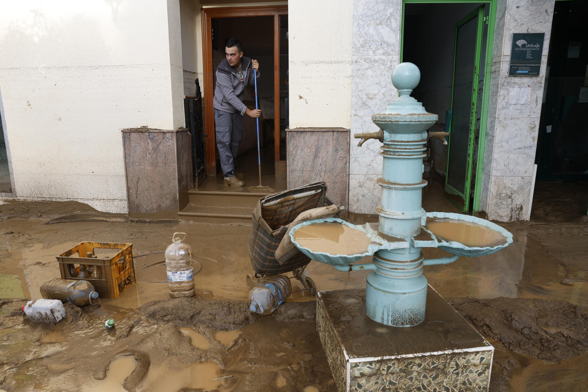 Un vecino colabora con las labores de retirada de lodo de las calles en la localidad malagueña de Benamargosa este jueves. EFE/ Jorge Zapata
