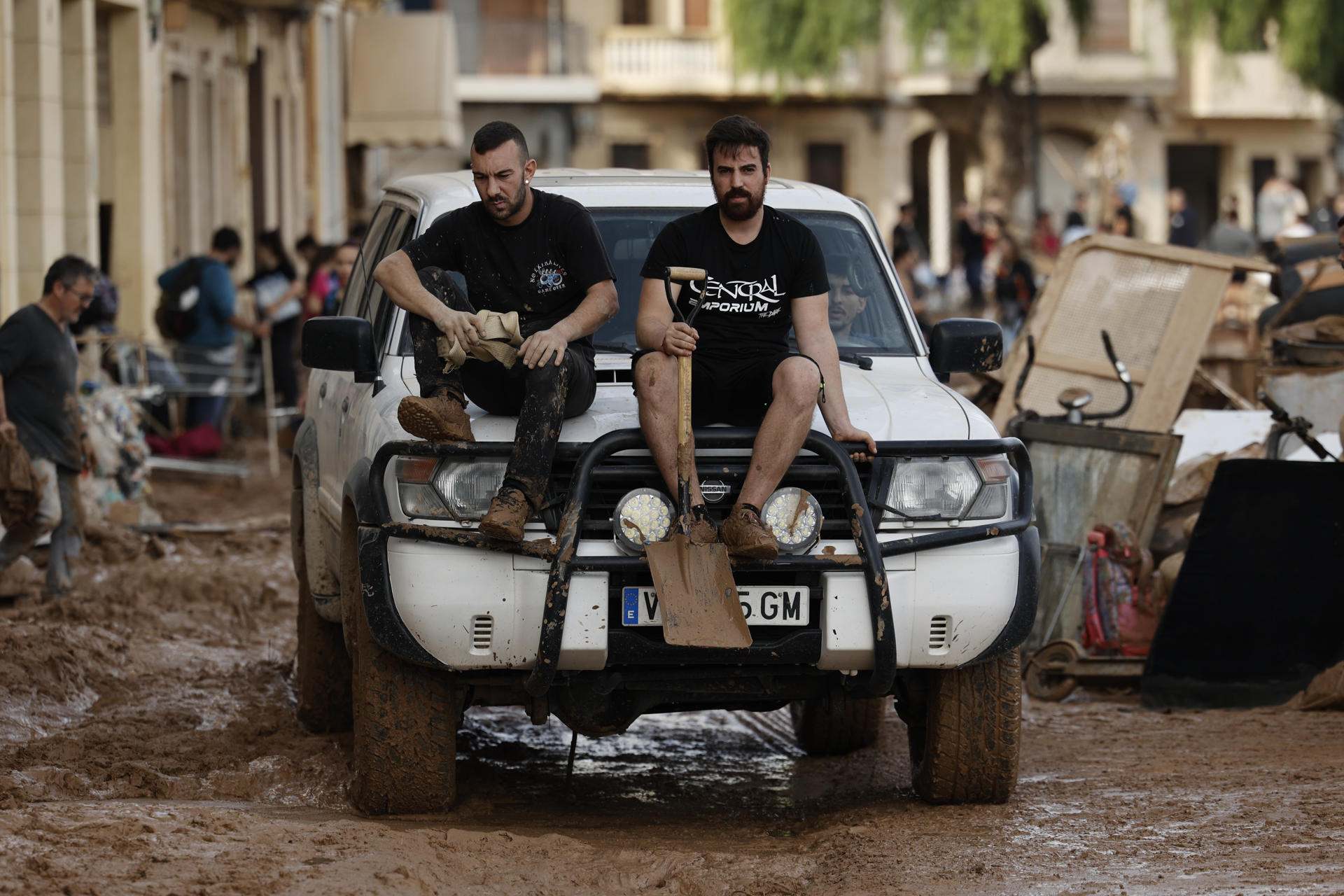 Vecinos de Paiporta trabajan en la limpieza de calles, locales y viviendas de la localidad junto a una montaña de vehículos arrastrados por la corriente, este viernes. Las víctimas mortales en la provincia de Valencia a causa de la devastadora dana ha aumentado este viernes hasta las 205, según el último recuento facilitado por el Centro de Emergencias de la Generalitat Valenciana. EFE/Biel Aliño
