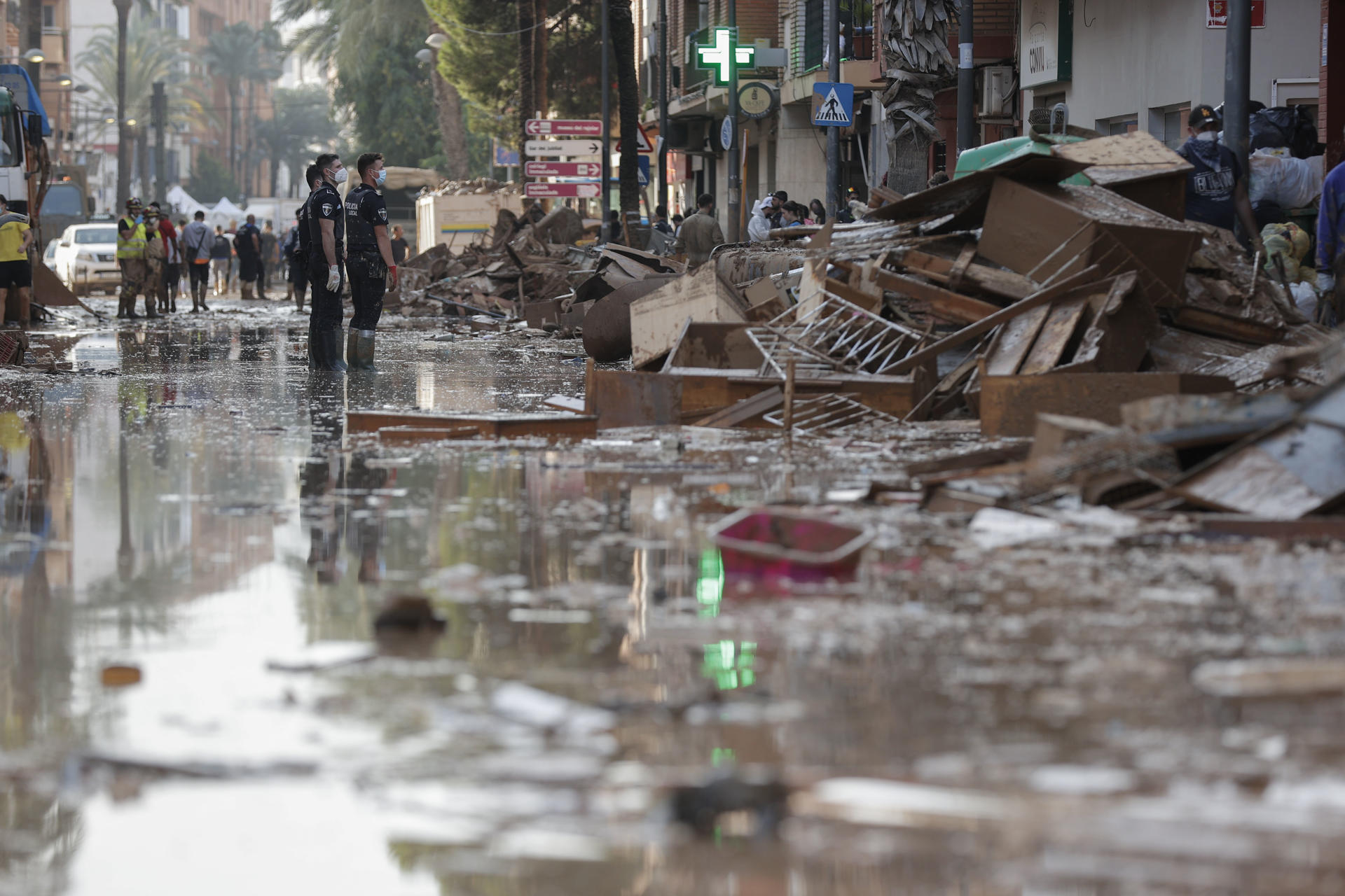 Voluntarios y vecinos trabajan para despejar una calle de Paiporta (Valencia), este martes. Una semana después del paso de la dana, varios de los pueblos más afectados siguen "en shock" y con grandes necesidades, más allá de comida o productos de limpieza y desescombro, a pesar de la ayuda de los miles de voluntarios y el aumento de efectivos de la UME, ejército, bomberos y policías. EFE/ Manuel Bruque
