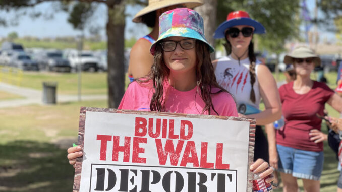 Fotografía de archivo de una mujer con un cartel antimingrantes durante un evento de campaña de Donald Trump. EFE/ Ana Milena Varon
