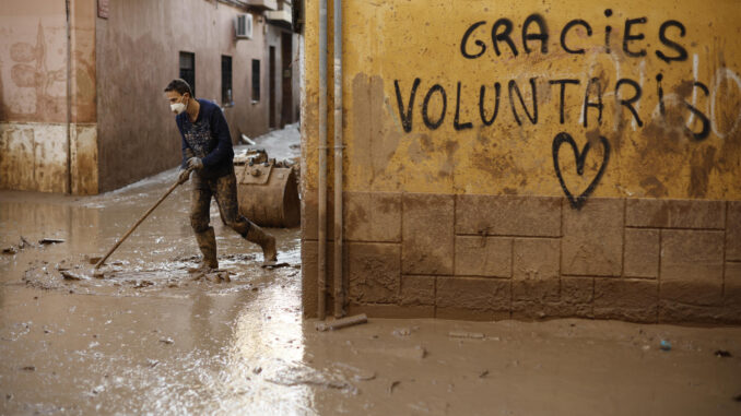 Un voluntario retira fango de una calle de Paiporta (Valencia) este jueves. Los pueblos de Valencia asolados por la dana afrontan el noveno día después de la catástrofe sumidos en un goteo incesante de llegada tanto de ayuda humanitaria como profesional y de maquinaria pesada, para intentar recuperar infraestructuras, colegios, zonas industriales y vías de comunicación mientras continúa la búsqueda de desaparecidos. EFE/ Biel Aliño
