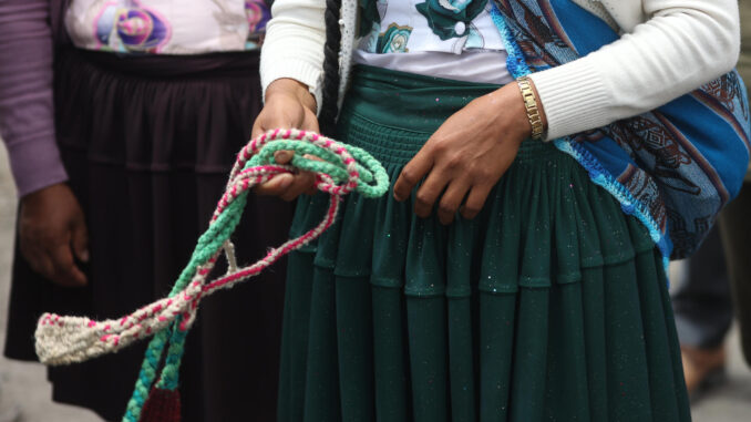 Una mujer sostiene una onda o 'Waraka' durante un entrenamiento en Parotani (Bolivia). EFE/ Luis Gandarillas
