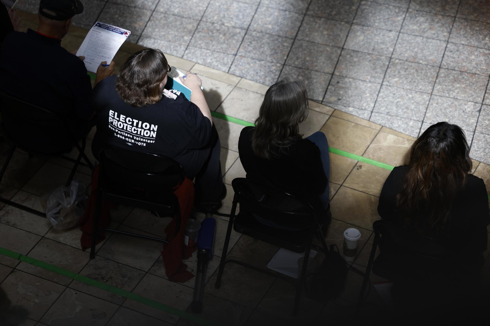 Observadores electorales se sientan cerca mientras la gente emite su voto en la Galleria At Sunset en Henderson, Nevada, EE. UU., el 5 de noviembre de 2024.EFE/EPA/CAROLINE BREHMAN
