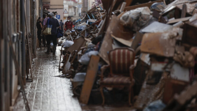 Voluntarios y vecinos trabajan para despejar una calle de Paiporta (Valencia), este martes. Una semana después del paso de la dana, varios de los pueblos más afectados siguen "en shock" y con grandes necesidades, más allá de comida o productos de limpieza y desescombro, a pesar de la ayuda de los miles de voluntarios y el aumento de efectivos de la UME, ejército, bomberos y policías. EFE/ Manuel Bruque
