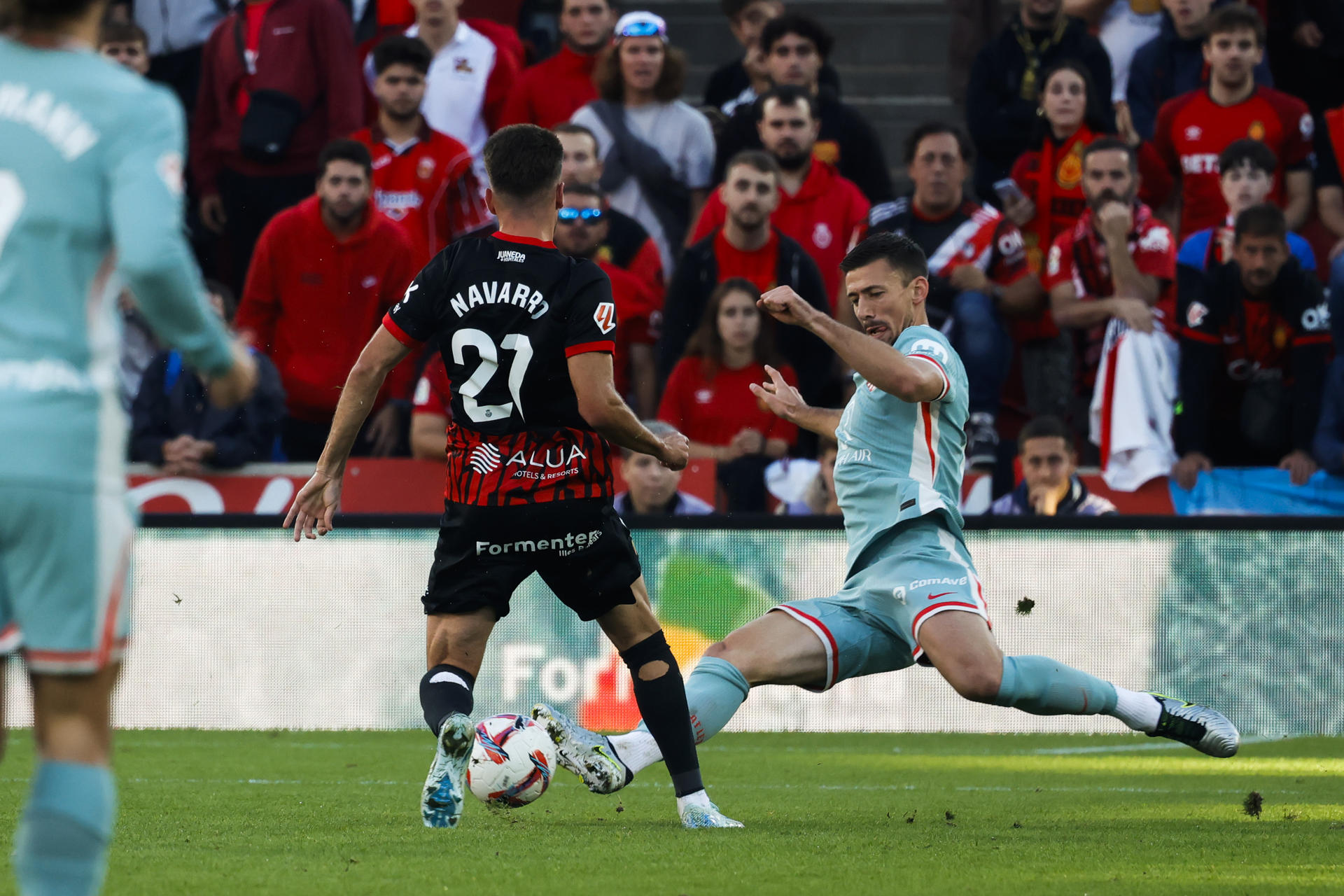 El centrocampista del Mallorca Robert Navarro (i) pelea un balón con el defensa francés Clément Lenglet, del Atlético de Madrid, durante el partido de LaLiga entre el Real Mallorca y el Atlético de Madrid, este domingo en el estadio de Soin Moix. EFE/CATI CLADERA
