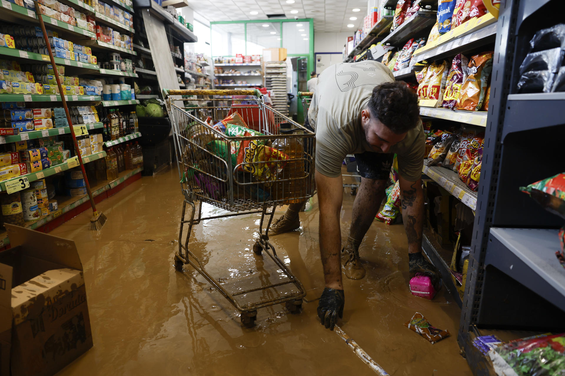 Labores de limpieza en un supermercado inundado de la localidad malagueña de Benamargosa tras las fuertes lluvias este jueves. La dana sobre el sur y extremo oriental del país, con cuantiosos daños en las últimas horas, rescates y vías cortadas por inundaciones, como en Málaga -ya sin riesgo- empieza a remitir pero el temporal azotará aún hoy a Andalucía, que está en alerta naranja (riesgo importante), así como a Valencia, aunque solo hasta media mañana. EFE/ Jorge Zapata
