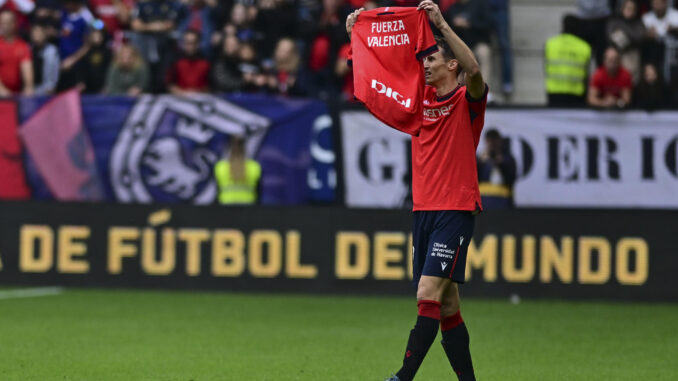 El jugador croata del Osasuna Ante Budimir muestra una camiseta con el mensaje 'Fuerza Valencia' antes del inicio del partido de la 12ª jornada de LaLiga contra el Osasuna en el Estadio de El Sadar, en Pamplona, este sábado. EFE/ Iñaki Porto
