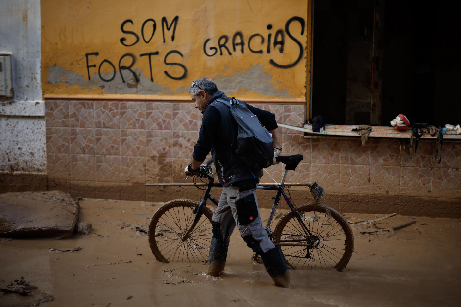 Un voluntario acude en bicicleta a la localidad de Paiporta, este jueves. Voluntarios, fuerzas de seguridad, bomberos, militares y vecinos de las localidades más afectadas por la dana continúan con las tareas de limpieza mientras los equipos de rescate siguen rastreando la zona para intentar localizar a las personas que aún sigue desaparecidas. EFE/Biel Aliño
