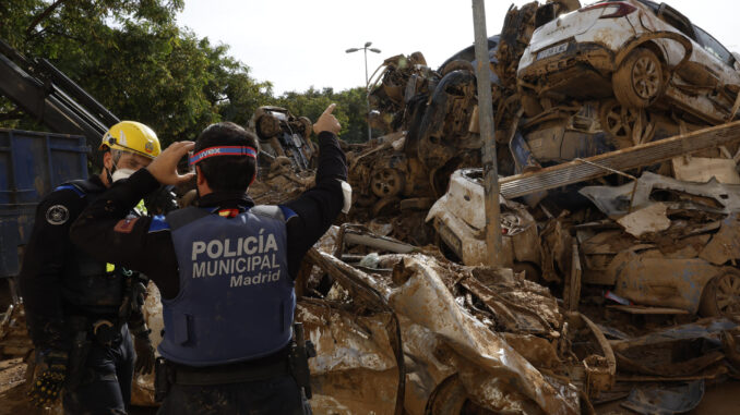 Efectivos de la Policía de Madrid colaboran en la retirada de vehículos arrasados por las riadas en Alfafar (Valencia). EFE/Chema Moya
