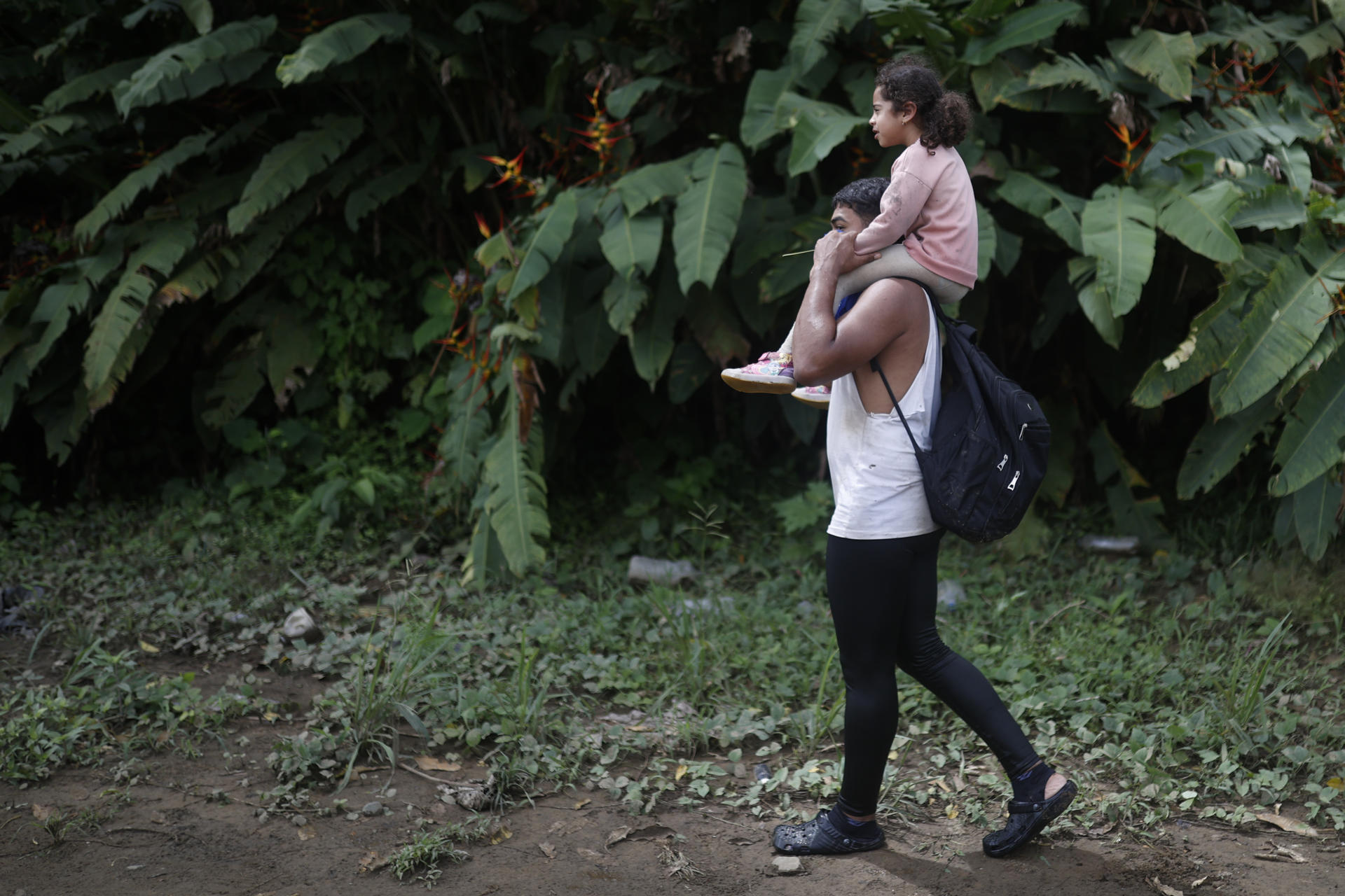 Un migrante y una niña llegan a registrarse en un puesto migratorio en la comunidad de Bajo Chiquito, este jueves en el Darien (Panamá). El director de la Aecid, Antón Leis, visitó esta semana el poblado al que llegan a diario cientos de migrantes tras atravesar durante días la peligrosa selva del Darién, la frontera natural entre Colombia y Panamá, donde recordó que nadie "recorre miles de kilómetros por capricho y mucho menos para cometer delitos", sino porque huyen de guerras, hambre o miseria, las causas profundas de la crisis migratoria global. EFE/ Bienvenido Velasco
