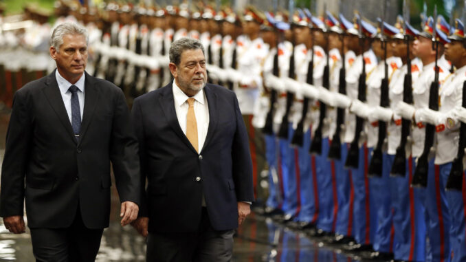 Fotografía de archivo del presidente de Cuba, Miguel Díaz Canel (i), junto al primer ministro de San Vicente y las Granadinas, Ralph Gonsalves (c), con una ceremonia de bienvenida en el Palacio de la Revolución en La Habana (Cuba). EFE/Ernesto Mastrascusa
