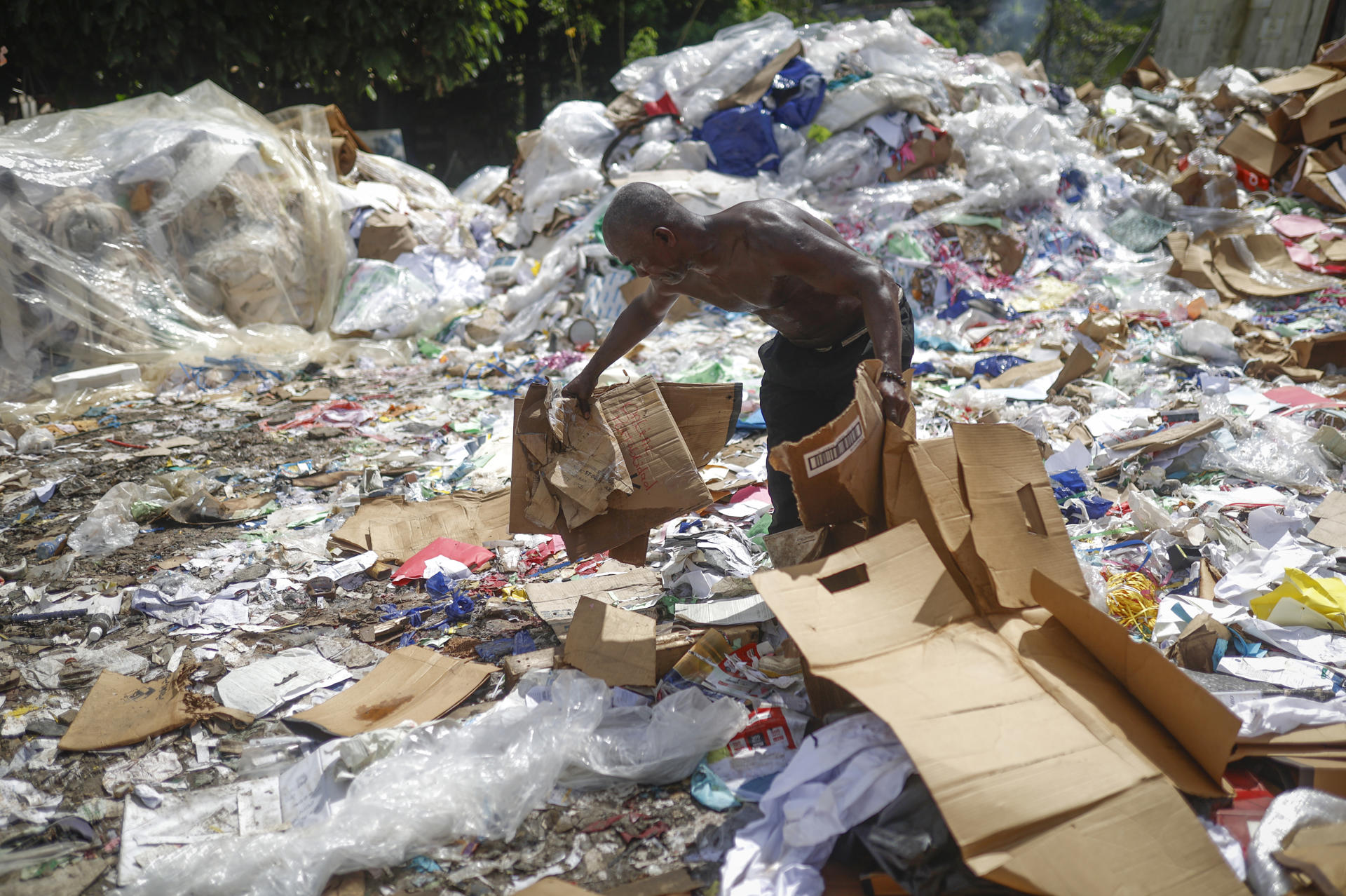 Un hombre busca material reciclable, este miércoles en la comunidad de Kuna Nega, en Ciudad de Panamá (Panamá). EFE/ Bienvenido Velasco
