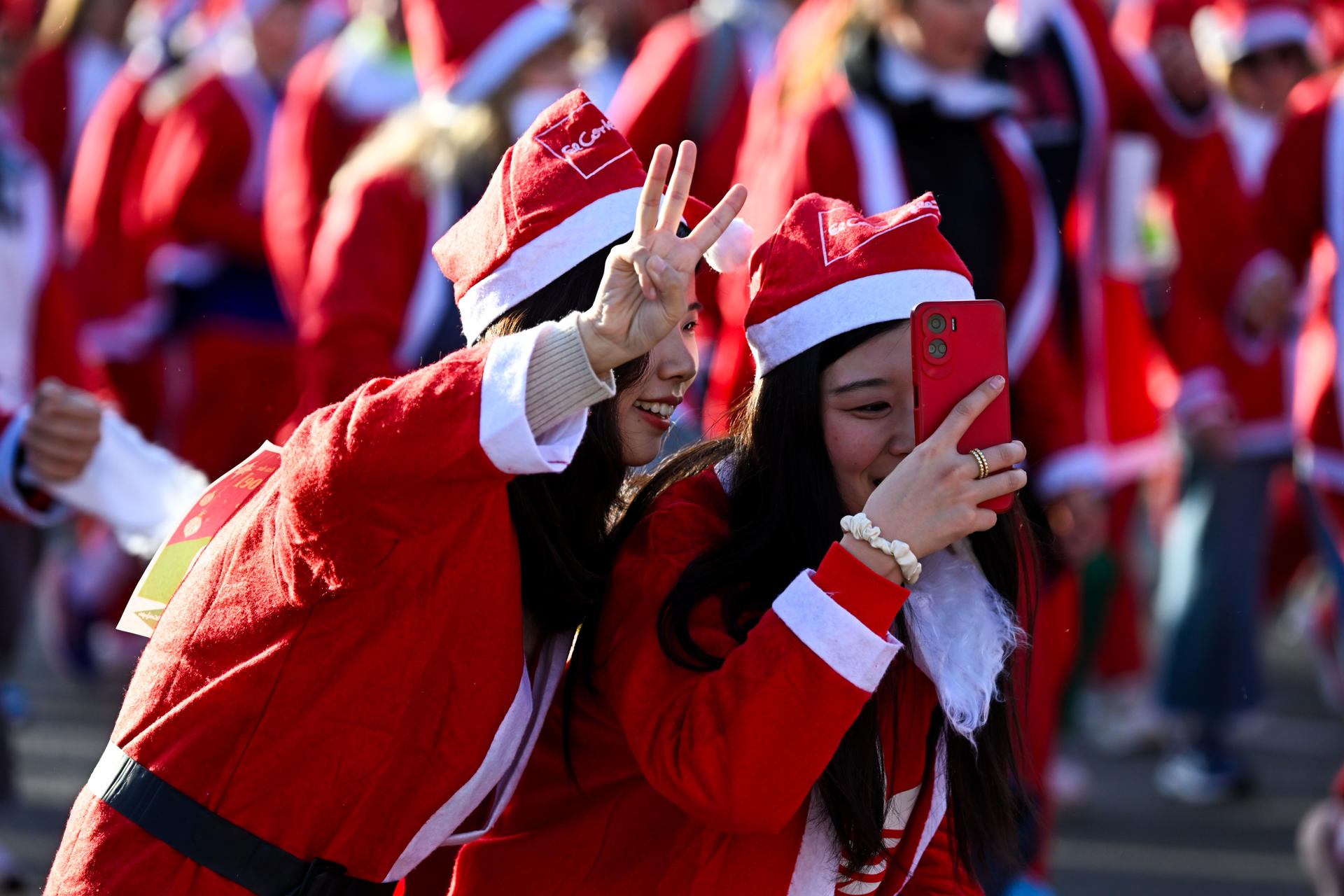 Miles de corredores vestidos de Papá Noel participan en esta tradicional Carrera de Navidad, que alcanza este año su XIII edición, en Madrid. EFE/Víctor Lerena
