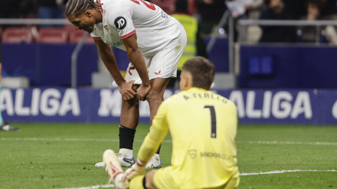 Los jugadores del Sevilla, el guardameta Álvaro Fernández (d) y el francés Loic Badé, tras encajar el cuarto gol durante el encuentro correspondiente a la jornada 16 de Laliga EA Sports que han disputado Atlético de Madrid y Sevilla en el estadio Metropolitano, en Madrid. EFE / Sergio Perez.
