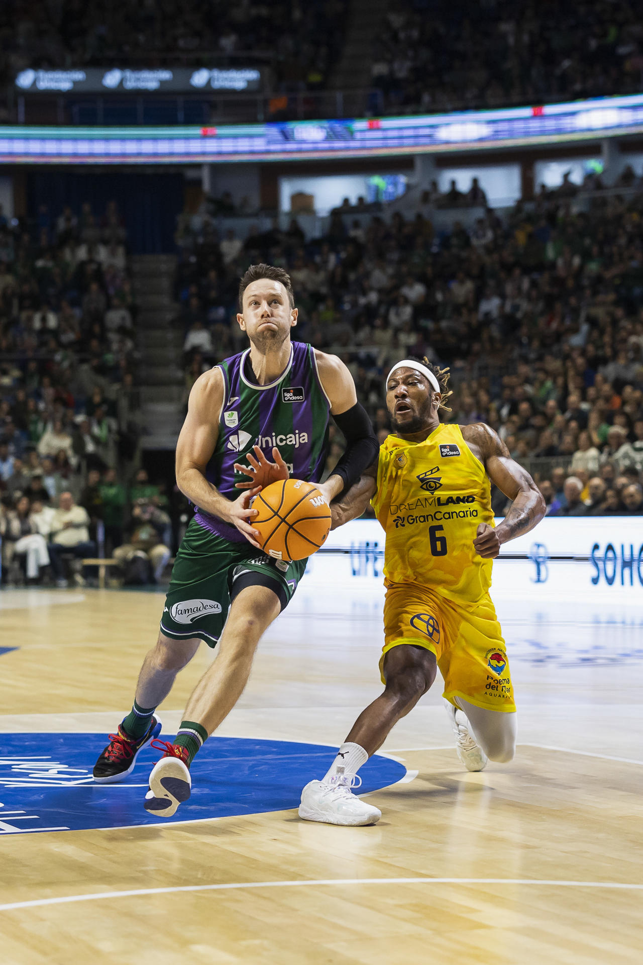 El escolta estadounidense del Unicaja, Tyler Kalinoski (i), entra a canasta ante la defensa del base francés del Dreamland Gran Canaria, Andrew Albicy, durante el partido de la jornada 11 de la Liga Endesa disputado en el Palacio de Deportes José María Martín Carpena. EFE/Carlos Díaz.
