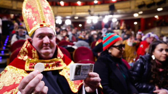 El obispo, apodado así por su ya icónico disfraz, ha sido el primero en acceder a la sala principal del Teatro Real pasadas las 7:30 horas tras 22 días de guardia a las puertas del teatro, y lo ha hecho portando también el primer número y el más bajo susceptible de ser premiado: el 00000. EFE/Javier Lizón
