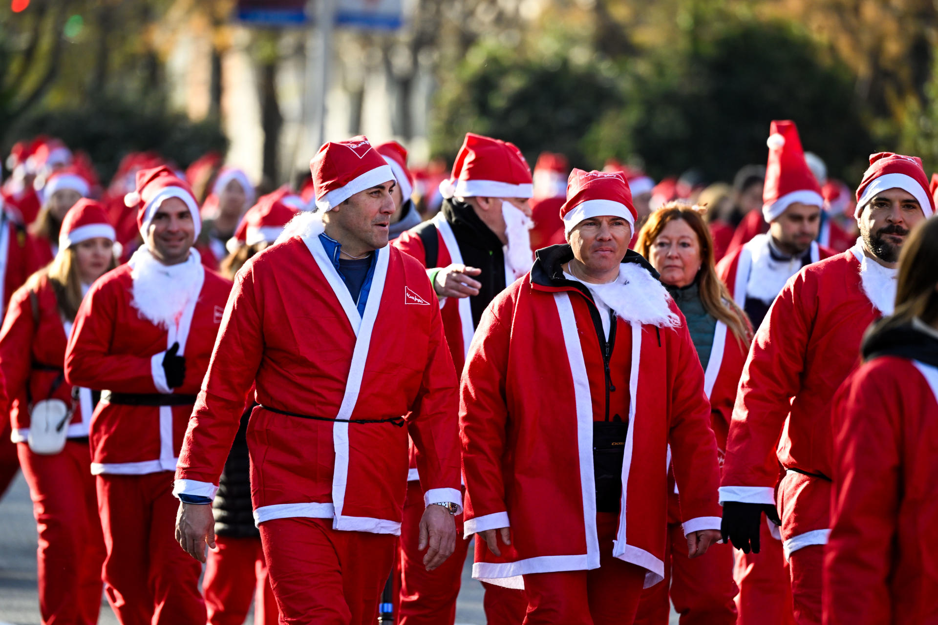 Miles de corredores vestidos de Papá Noel participan en esta tradicional Carrera de Navidad, que alcanza este año su XIII edición en Madrid. EFE/Víctor Lerena
