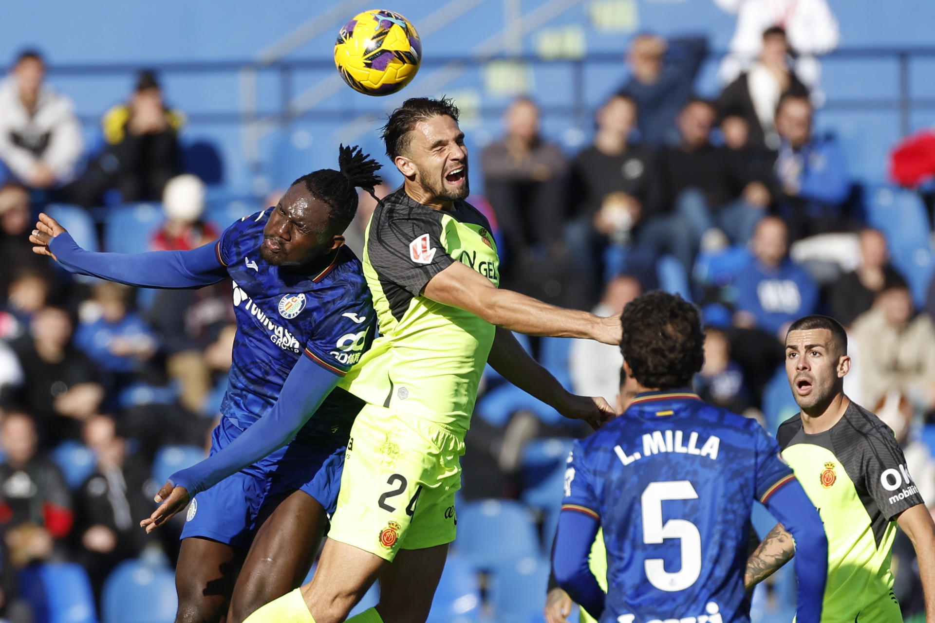 Chrisantus Uche (i), del Getafe, pelea por un balón de cabeza con Martin Valjent (2i), del Mallorca, durante el partido de LaLiga que enfrenta a sus equipos este sábado en el Coliseum en Getafe. EFE/ Juanjo Martín
