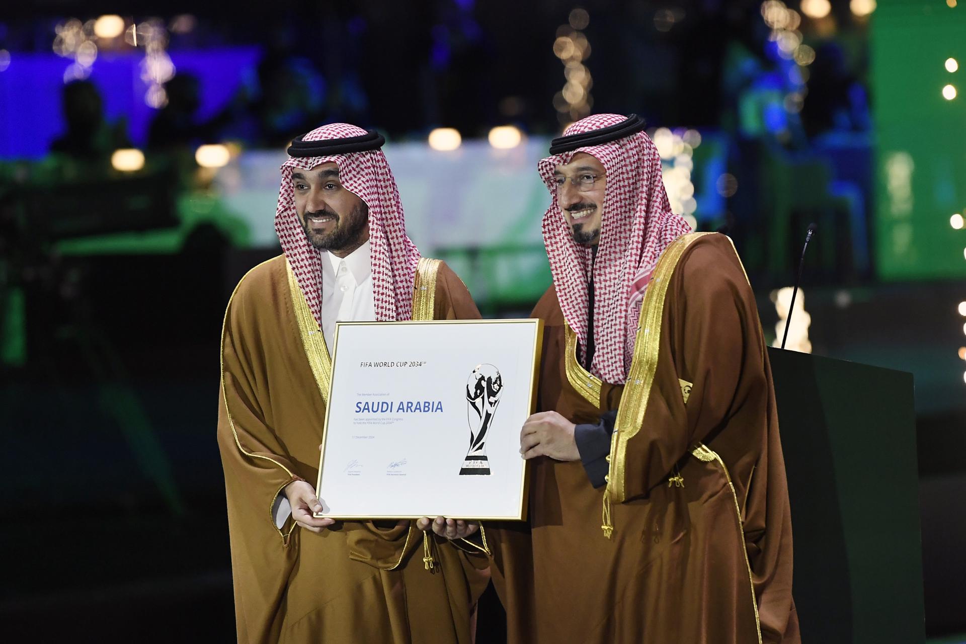 El ministro de deportes saudí Abdulaziz bin Turki al-Faisal al-Saud (I) y el presidente de la Federación de Fútbol de Arabia Saudí Yasser Al Misehal posa con la foto que acredita a Arabia Saudí como la organizadora del Mundial de 2034. EFE/EPA/STRINGER
