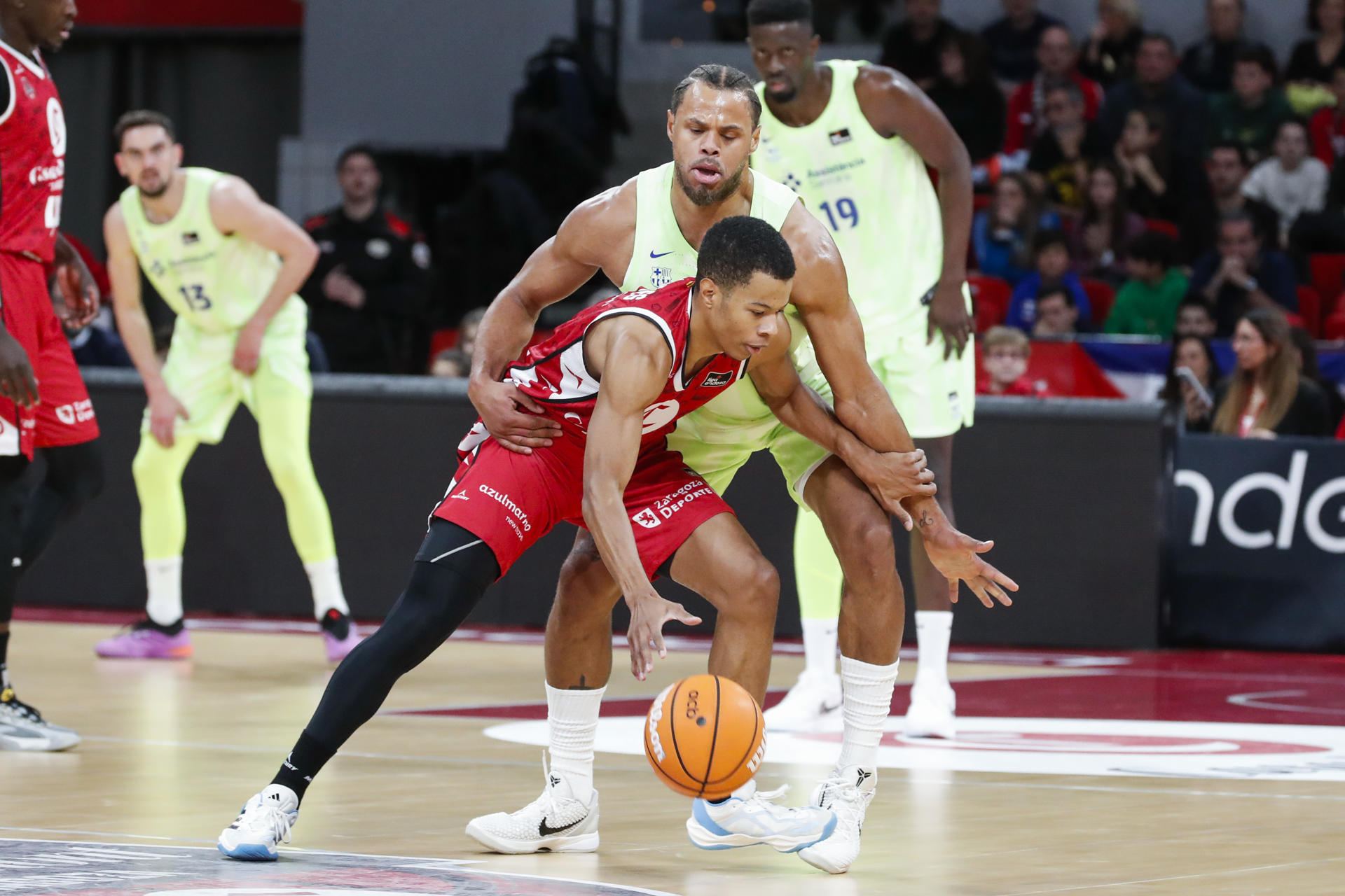 El base del Casademont Zaragoza Trae Bell-Haynes (delante) controla el balón ante Justin Anderson, del Barça, durante el partido de la jornada 11 de la Liga Endesa de Baloncesto que Casademont Zaragoza y Barça disputaron en el pabellón Príncipe Felipe, en Zaragoza.- EFE/ Javier Belver
