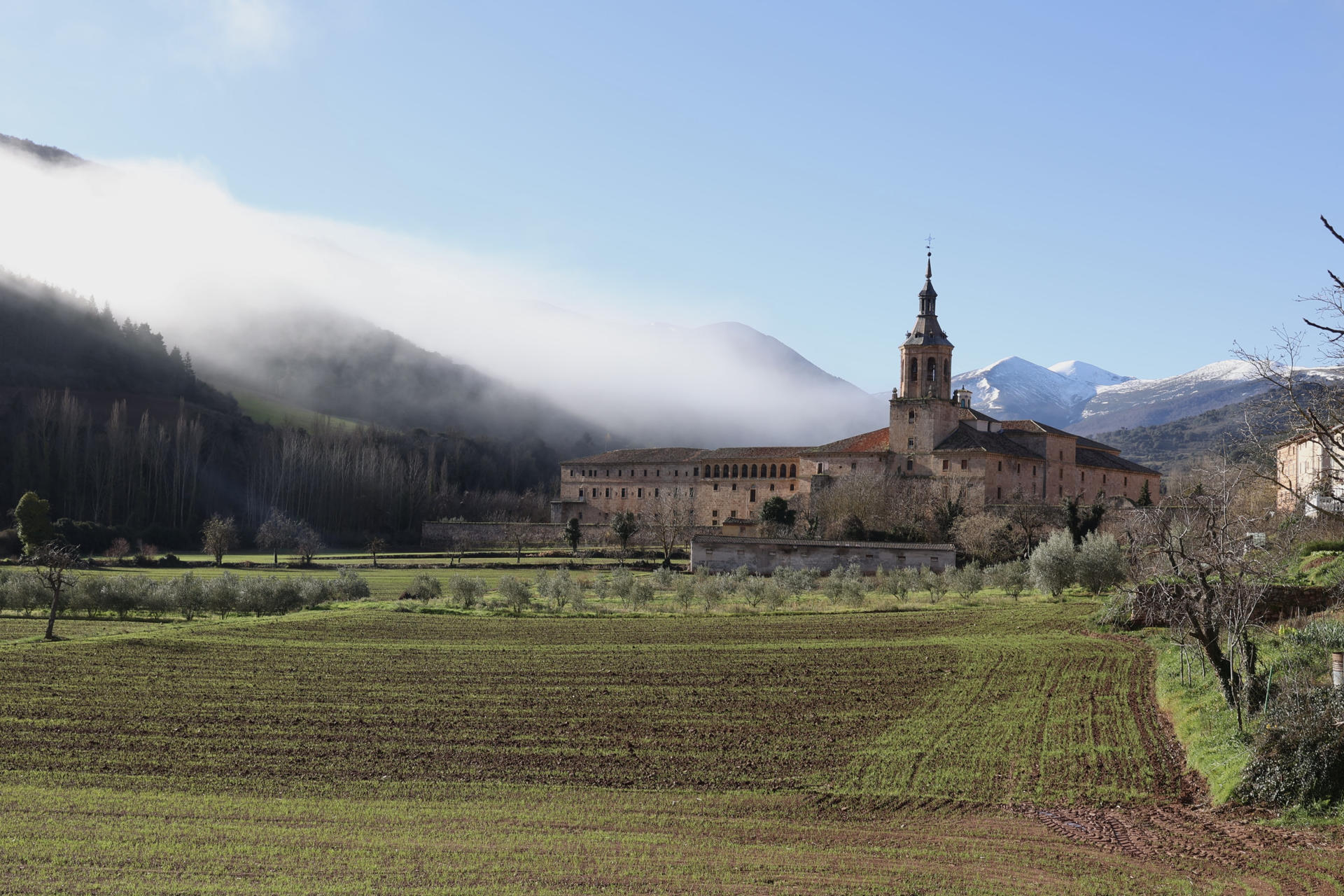 Niebla en el valle de San Millán de la Cogolla deja al descubierto el Monasterio de Yuso y el Pico de San Lorenzo y Cabeza Parda, cubiertos por la nieve. Seis comunidades autónomas se encuentran hoy, día de Navidad, en alerta amarilla por niebla o fenómenos costeros, en el caso de Cataluña por ambos, según la Agencia Estatal de Meteorología (Aemet) en su página web. EFE/Raquel Manzanares
