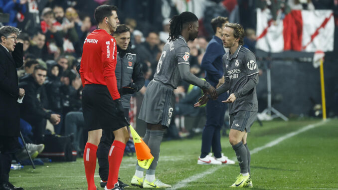 El centrocampista del Real Madrid Eduardo Camavinga (c) entra al campo por Modric durante el encuentro correspondiente a la jornada 17 de LaLiga EA Sports en el estadio de Vallecas, en Madrid. EFE / Juanjo Martín.
