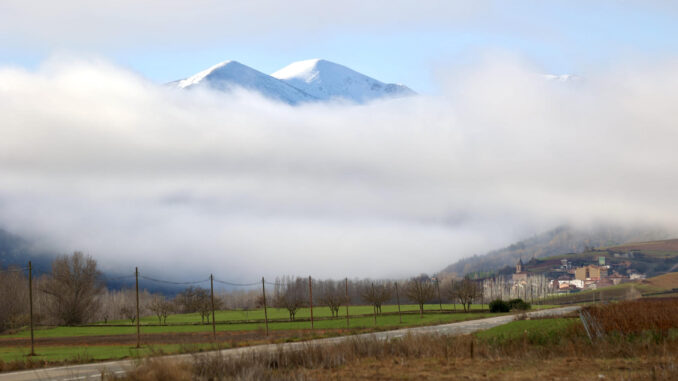 La niebla cubre este miércoles el Valle de San Millán de la Cogolla dejando al descubierto el Pico de San Lorenzo y Cabeza Parda, cubiertos por la nieve. Seis comunidades autónomas se encuentran hoy, día de Navidad, en alerta amarilla por niebla o fenómenos costeros, en el caso de Cataluña por ambos, según la Agencia Estatal de Meteorología (Aemet) en su página web. EFE/Raquel Manzanares
