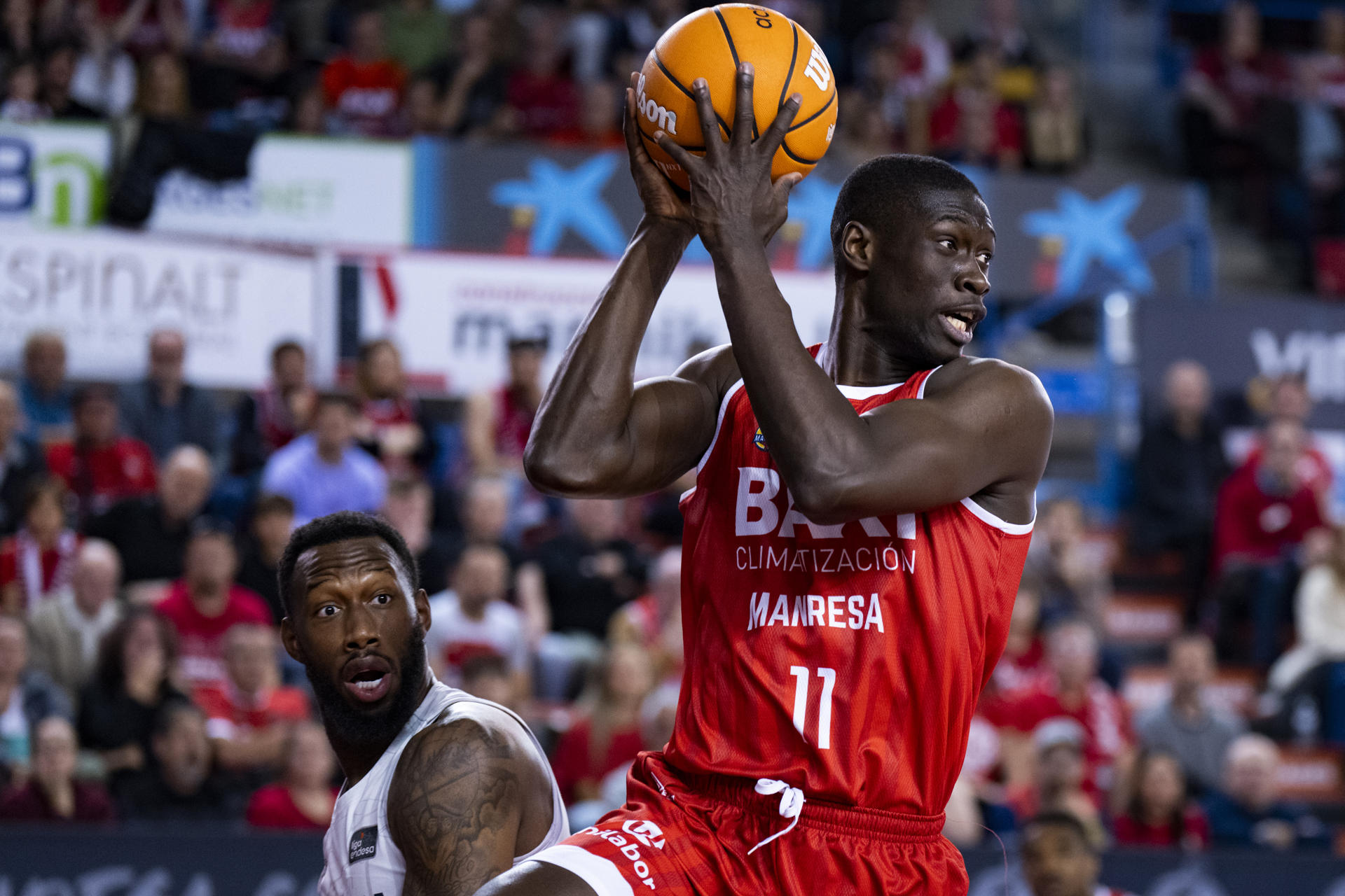 El pívot francés del Baxi Manresa Bodian Massa coge un rebote durante el encuentro de la jornada decimotercera de la Liga Endesa entre el Baxi Manresa y el Saski Baskonia, este domingo en el Pabellón Nou Congost de Manresa. EFE/Siu Wu
