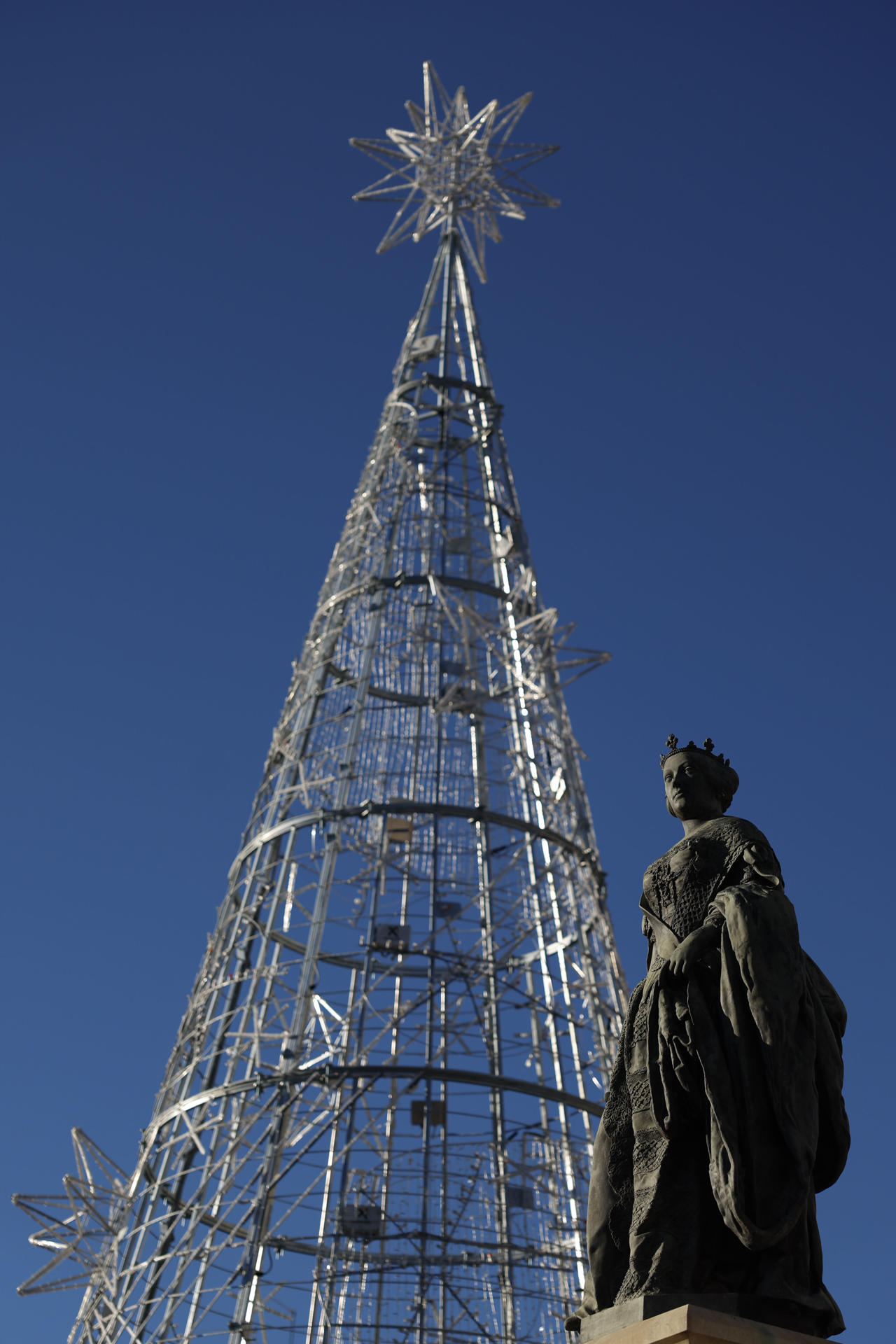 Un árbol de Navidad luce junto a la estatua de Isabel II en Ópera, Madrid, este jueves. EFE/ Mariscal
