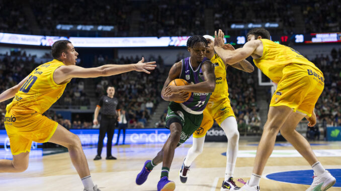 El base estadounidense del Unicaja, Tyson Carter (c), entra a canasta ante la defensa de varios jugadores del Dreamland Gran Canaria, durante el partido de la jornada 11 de la Liga Endesa disputado en el Palacio de Deportes José María Martín Carpena. EFE/Carlos Díaz.
