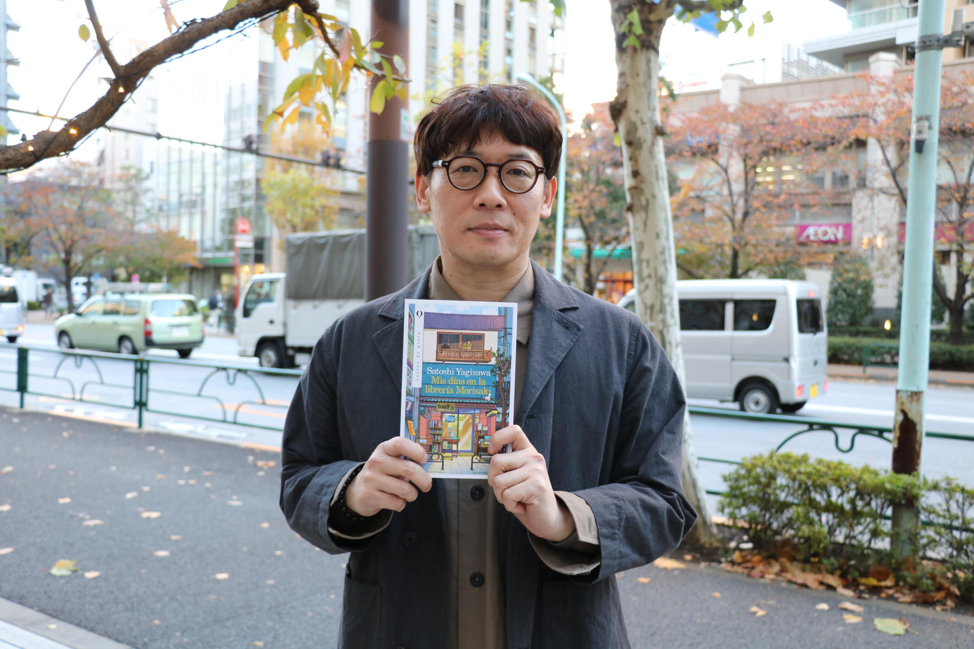 El autor nipón Satoshi Yagisawa posa con su libro 'Mis días en la librería Morisaki', un éxito editorial representante de la llamada 'cozy fiction' o literatura "amable" japonesa, que se caracteriza por tramas que transmiten paz y seguridad y con abundancia de café y gatos. EFE/ Sara Rodríguez Pachón
