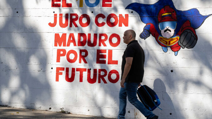 Un hombre camina frente a un mural con el mensaje "El 10E juro con Maduro por el futuro" este viernes, en Caracas (Venezuela). EFE/ Ronald Peña R.
